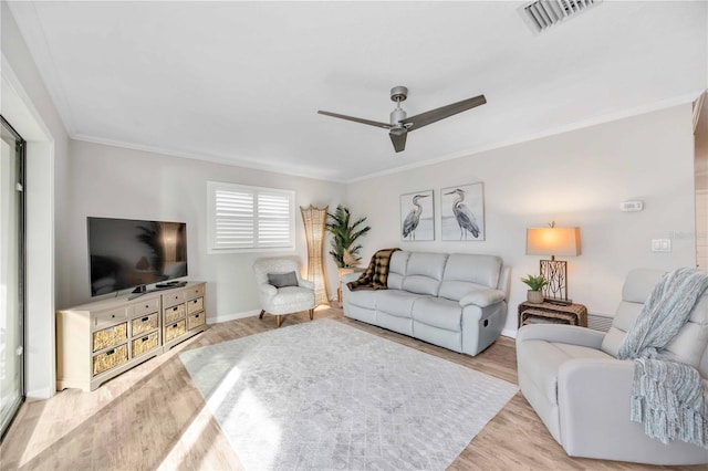 living room with ornamental molding, ceiling fan, and light hardwood / wood-style flooring