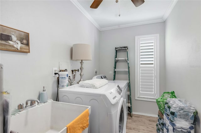 clothes washing area featuring sink, ceiling fan, crown molding, washer and clothes dryer, and light hardwood / wood-style flooring