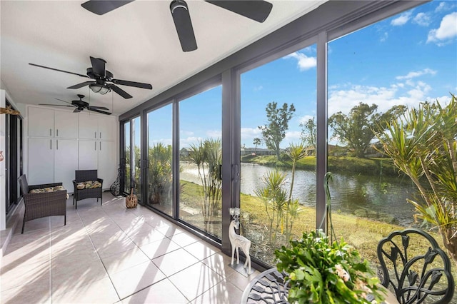 unfurnished sunroom featuring ceiling fan and a water view