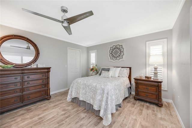 bedroom with crown molding, ceiling fan, light hardwood / wood-style floors, and a closet