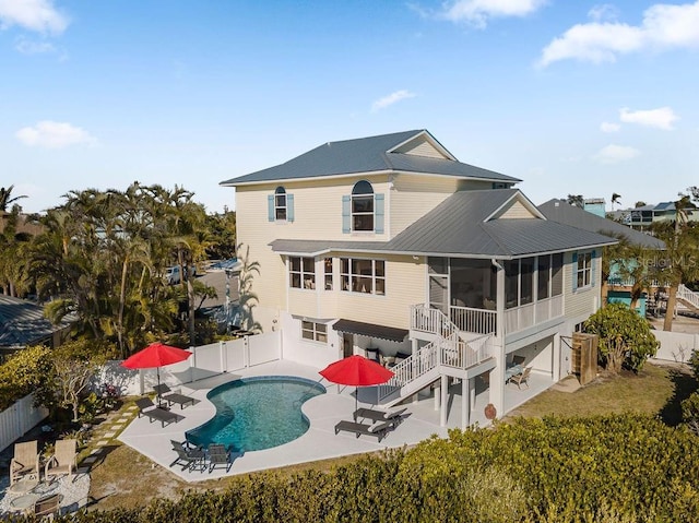 back of house with a patio, a fenced in pool, and a sunroom