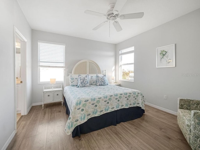 bedroom featuring multiple windows, wood-type flooring, and ceiling fan