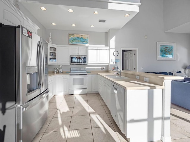 kitchen featuring stainless steel appliances, sink, white cabinets, and kitchen peninsula