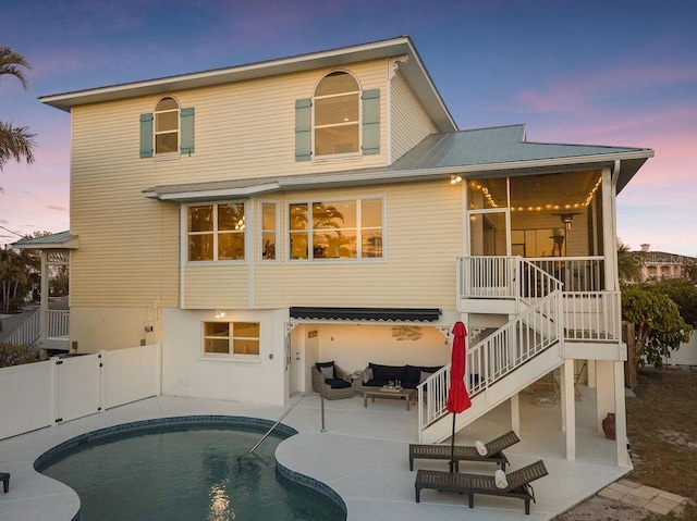 back house at dusk featuring an outdoor hangout area and a patio area