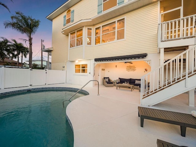 pool at dusk with an outdoor hangout area and a patio area