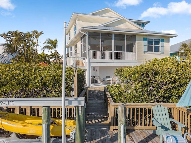 114 Gull Dr, Anna Maria, FL 34216 - rear view of house with a sunroom and a wooden deck