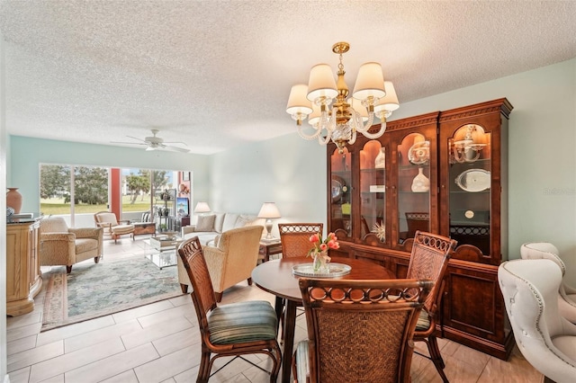 dining space featuring ceiling fan with notable chandelier, a textured ceiling, and light tile patterned flooring