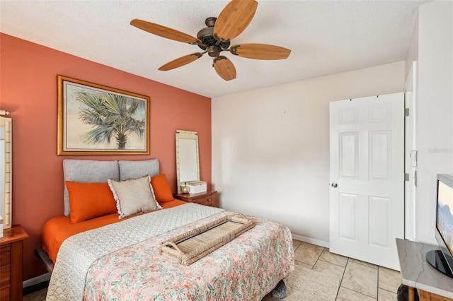 tiled bedroom featuring a textured ceiling and ceiling fan