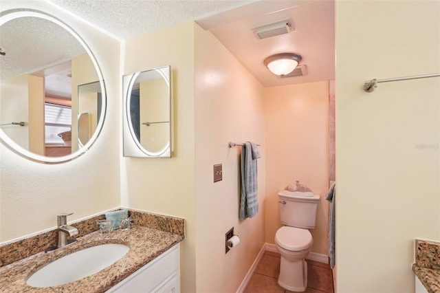 bathroom featuring tile patterned flooring, vanity, a textured ceiling, and toilet