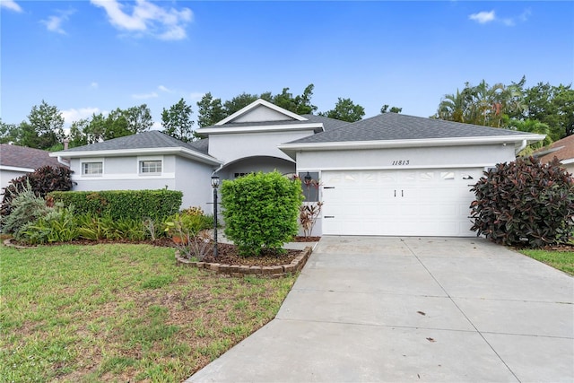 single story home featuring a garage and a front lawn