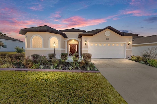 view of front of property with a garage and a yard