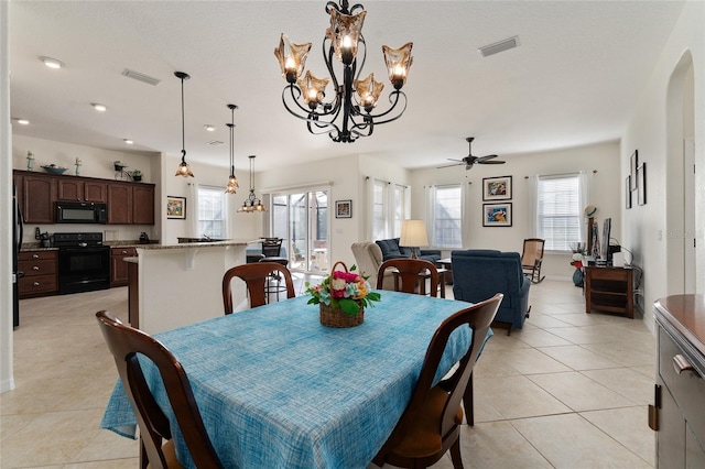 dining space featuring ceiling fan with notable chandelier and light tile patterned floors