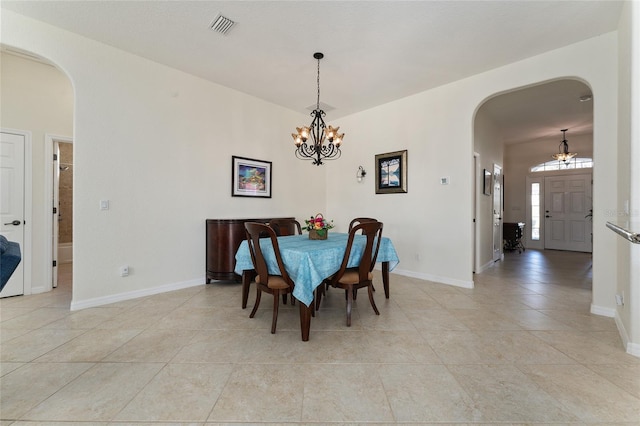 tiled dining room with a notable chandelier