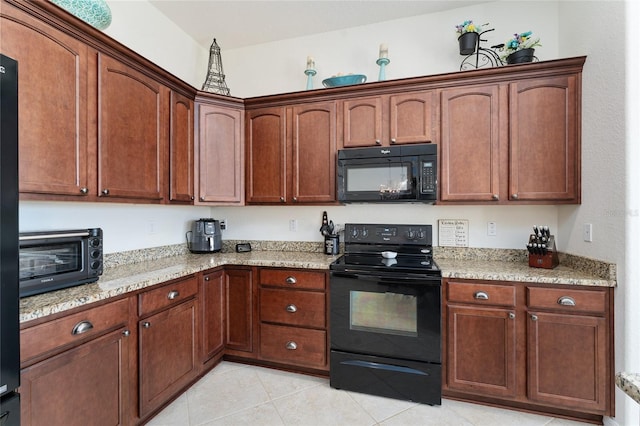 kitchen with light stone countertops, light tile patterned floors, and black appliances