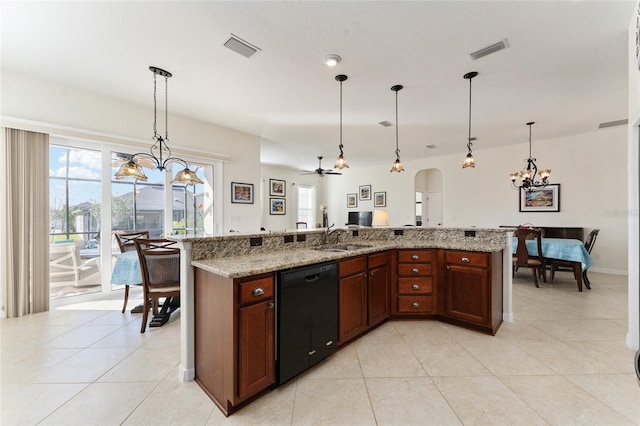 kitchen featuring sink, decorative light fixtures, an island with sink, and black dishwasher