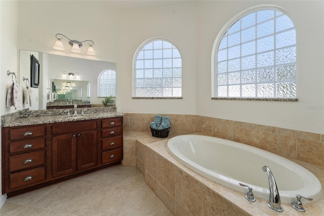 bathroom with vanity, tile patterned floors, and tiled bath