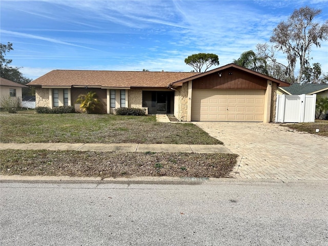 ranch-style home with a garage and a front lawn