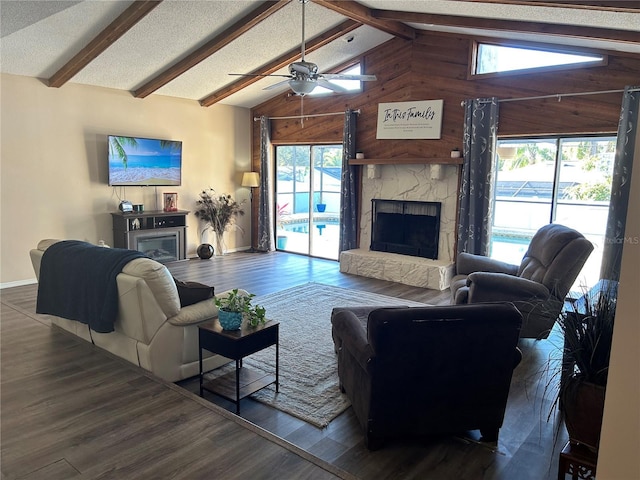 living room with dark hardwood / wood-style flooring, vaulted ceiling with beams, a fireplace, and plenty of natural light