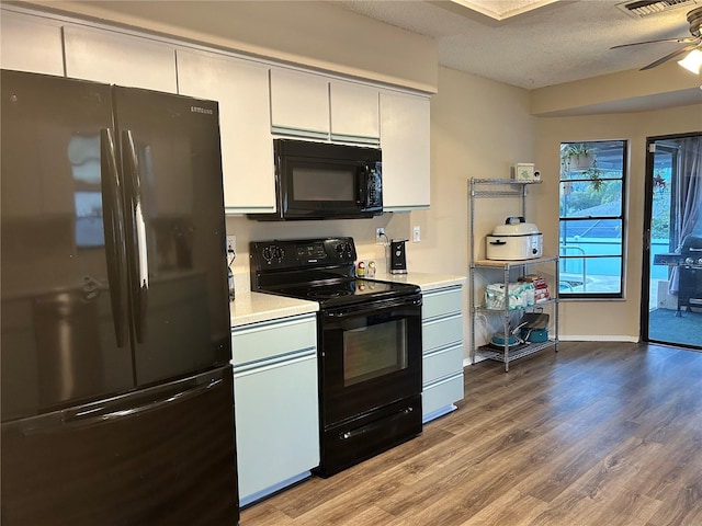 kitchen featuring hardwood / wood-style flooring, ceiling fan, black appliances, a textured ceiling, and white cabinets