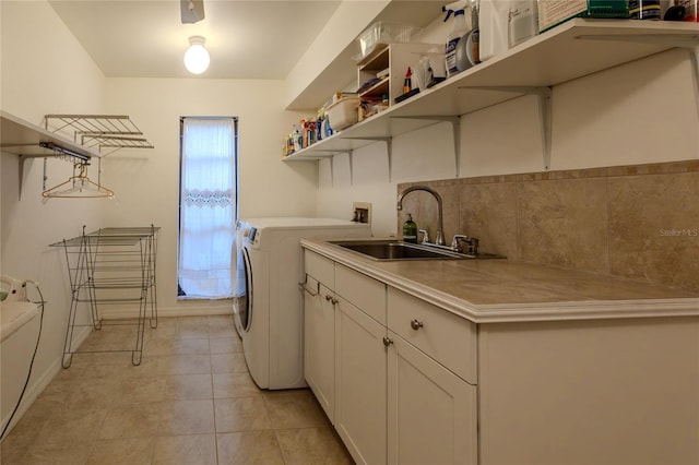 laundry room featuring separate washer and dryer, sink, light tile patterned floors, and cabinets