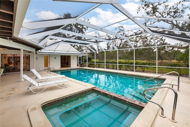 view of swimming pool featuring a lanai, a patio area, and an in ground hot tub