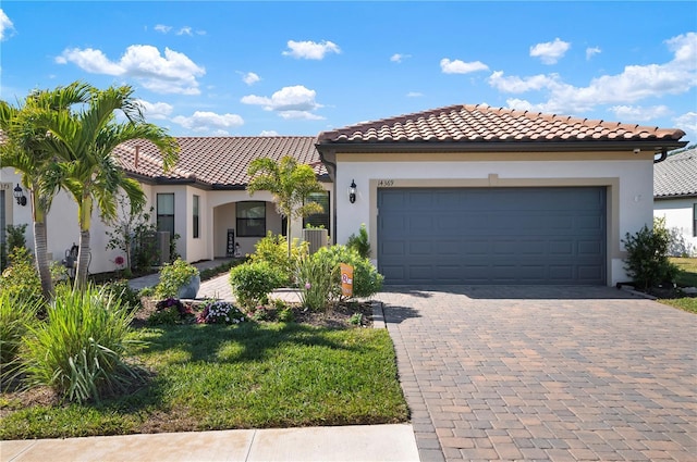 mediterranean / spanish home with a garage, a front yard, and central air condition unit