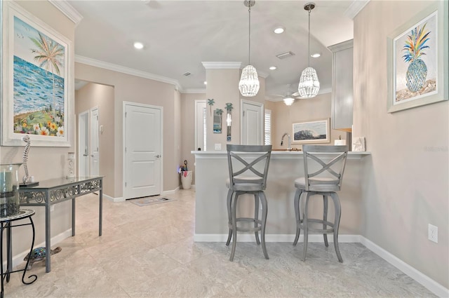 kitchen featuring decorative light fixtures, ornamental molding, and a kitchen breakfast bar