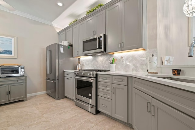 kitchen with ornamental molding, appliances with stainless steel finishes, sink, and gray cabinetry