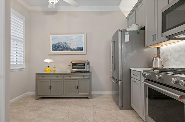 kitchen featuring appliances with stainless steel finishes, gray cabinetry, backsplash, ceiling fan, and crown molding