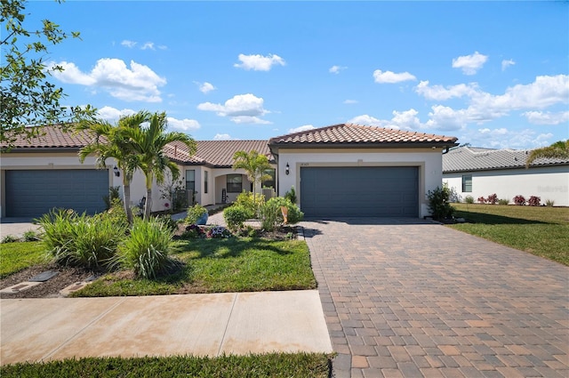 mediterranean / spanish-style home featuring a garage and a front lawn