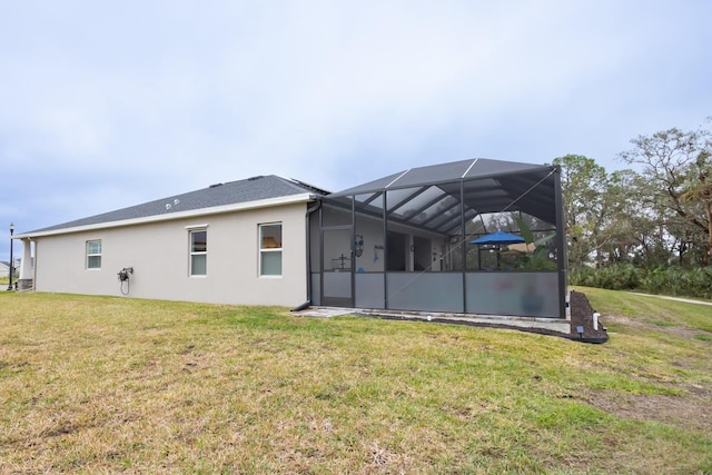 back of property with a yard and a lanai