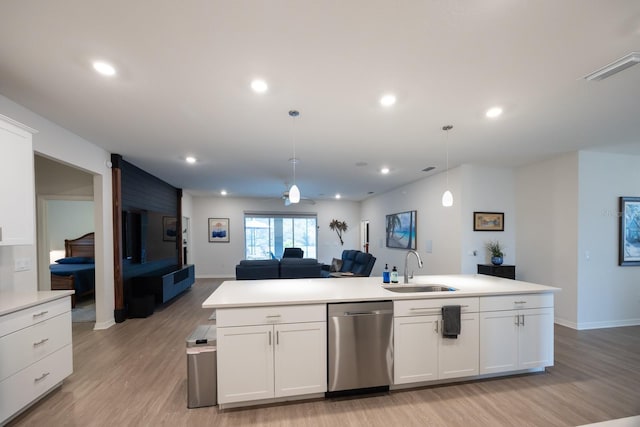 kitchen with pendant lighting, white cabinetry, dishwasher, and sink