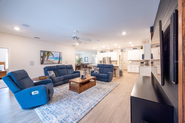 living room featuring ceiling fan and light hardwood / wood-style floors