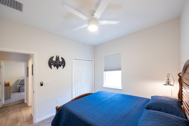 bedroom with light colored carpet, ceiling fan, and a closet