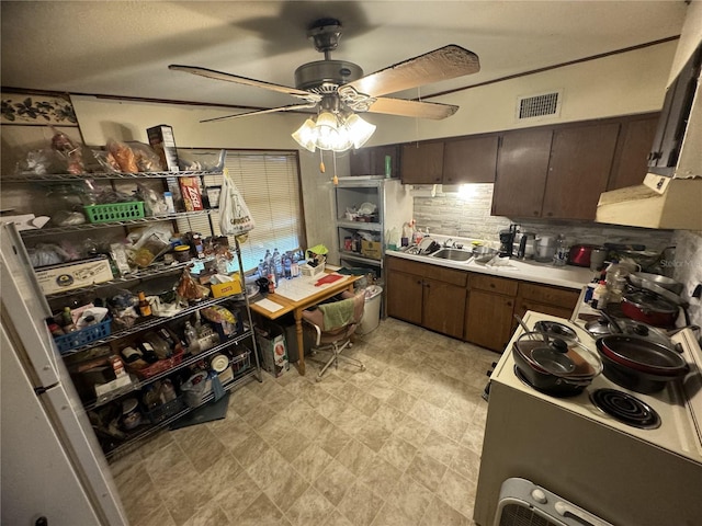 kitchen featuring sink, ceiling fan, backsplash, dark brown cabinetry, and a textured ceiling