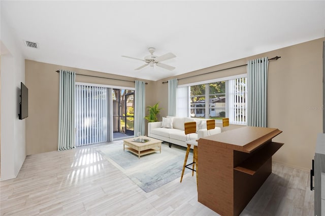 living room with ceiling fan and light wood-type flooring