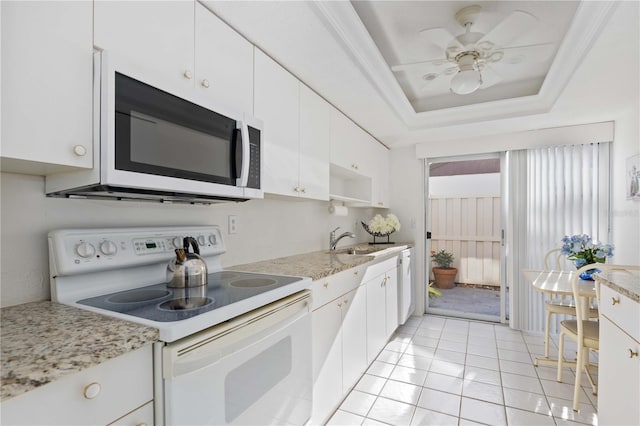 kitchen featuring light tile patterned flooring, sink, white cabinetry, a raised ceiling, and white appliances