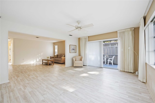 living area featuring ceiling fan, light hardwood / wood-style floors, and a healthy amount of sunlight