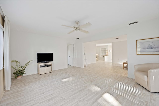 living room with light hardwood / wood-style flooring and ceiling fan