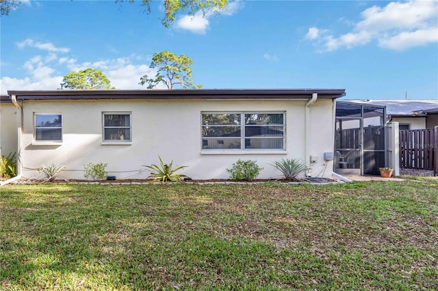 view of side of property featuring a sunroom and a yard