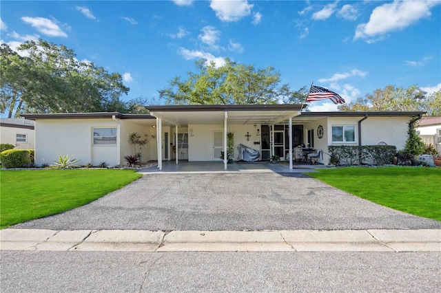 ranch-style home with a carport and a front yard