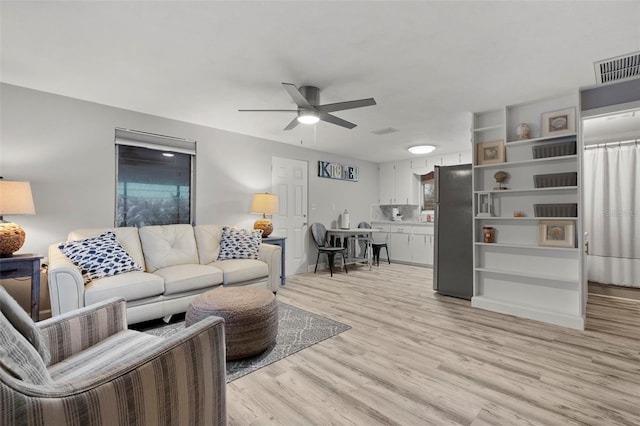 living room featuring ceiling fan and light hardwood / wood-style floors