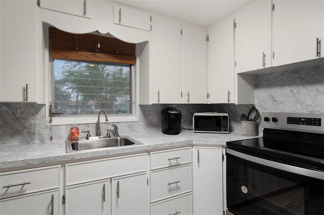 kitchen featuring white cabinetry, sink, electric range, and backsplash