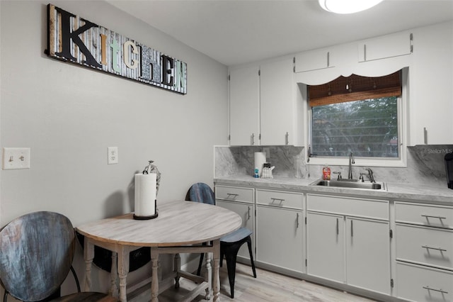 kitchen with white cabinetry, sink, and backsplash