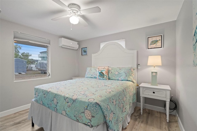 bedroom featuring a wall mounted air conditioner, ceiling fan, and light hardwood / wood-style floors