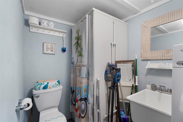 bathroom with sink, a textured ceiling, and toilet