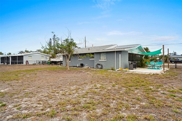 rear view of property featuring a patio and central air condition unit