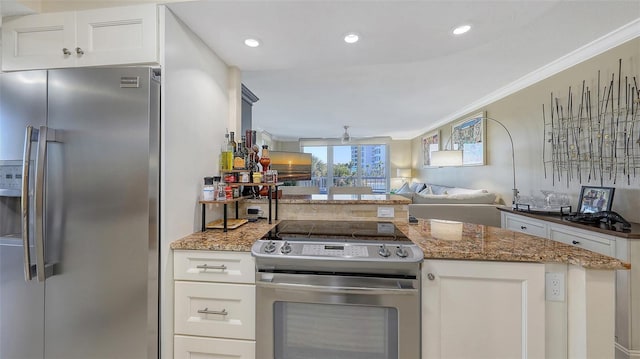 kitchen featuring crown molding, dark stone countertops, ceiling fan, stainless steel appliances, and white cabinets