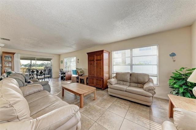 living room with a textured ceiling and light tile patterned floors