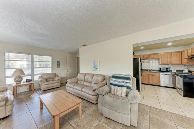 living room featuring light tile patterned flooring, sink, and a textured ceiling